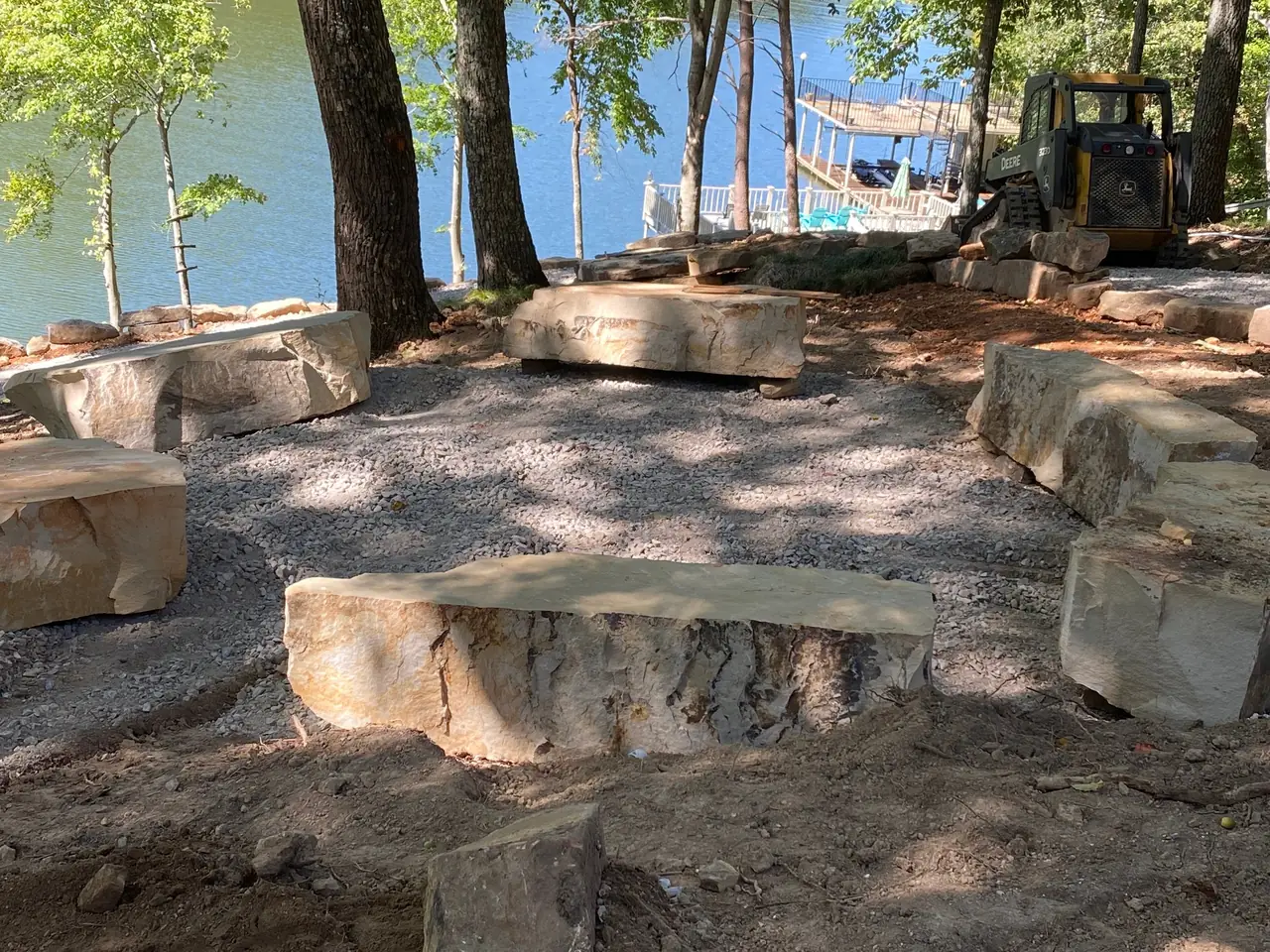 Boulder seating around a gravel fire pit by the lake