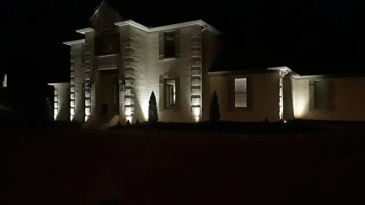 A house front washed with light at night