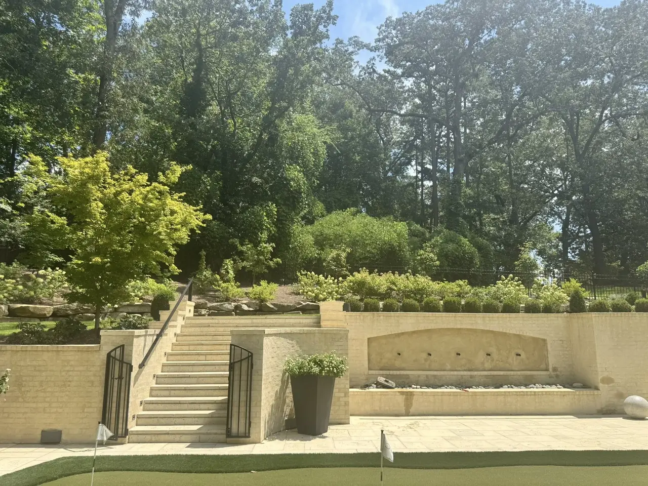 A limestone stair and terrace with a fountain wall