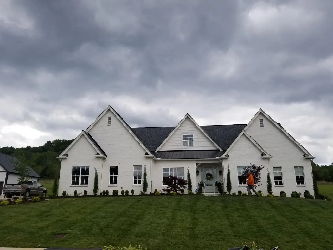 A new lawn in front of a white farmhouse