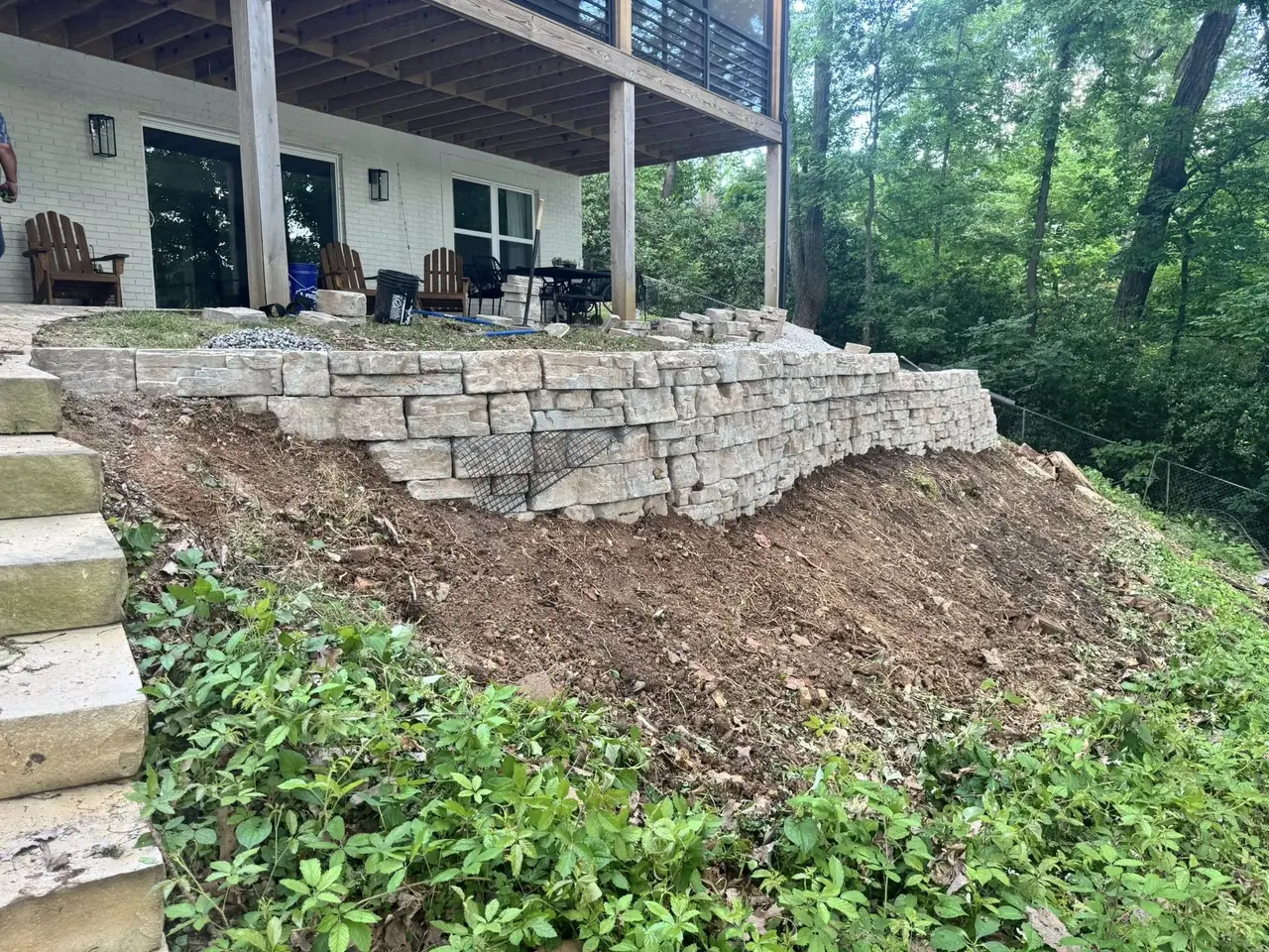 A new stone retaining wall under a deck before planting