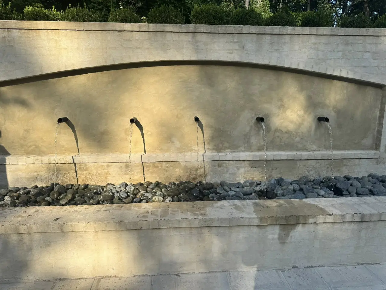 A plastered scupper wall fountain in daylight