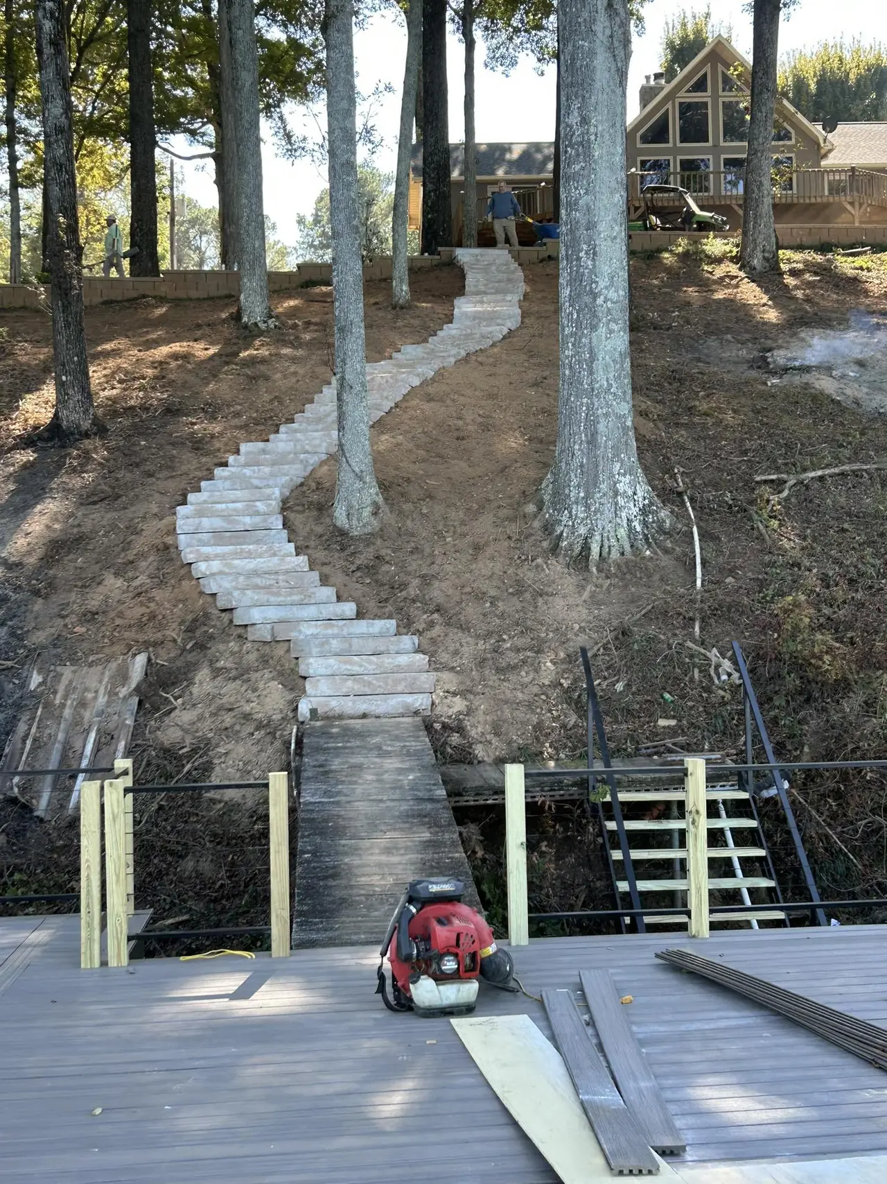 A stone path and steps down a wooded lake slope