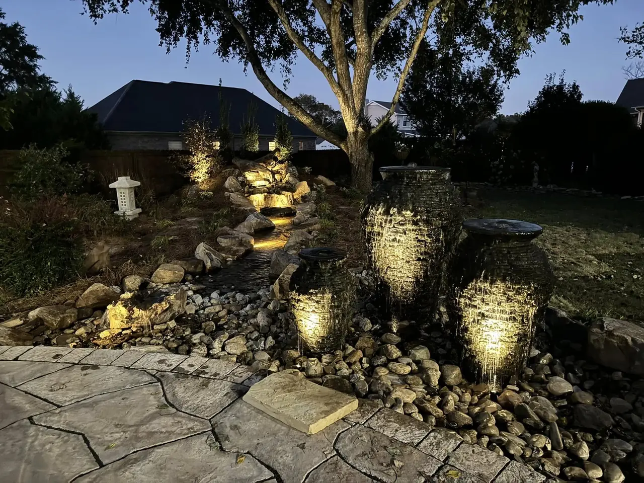 Urn fountains and a rock garden lit at night