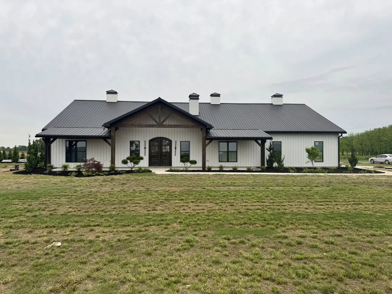 A wide new lawn in front of a white farmhouse