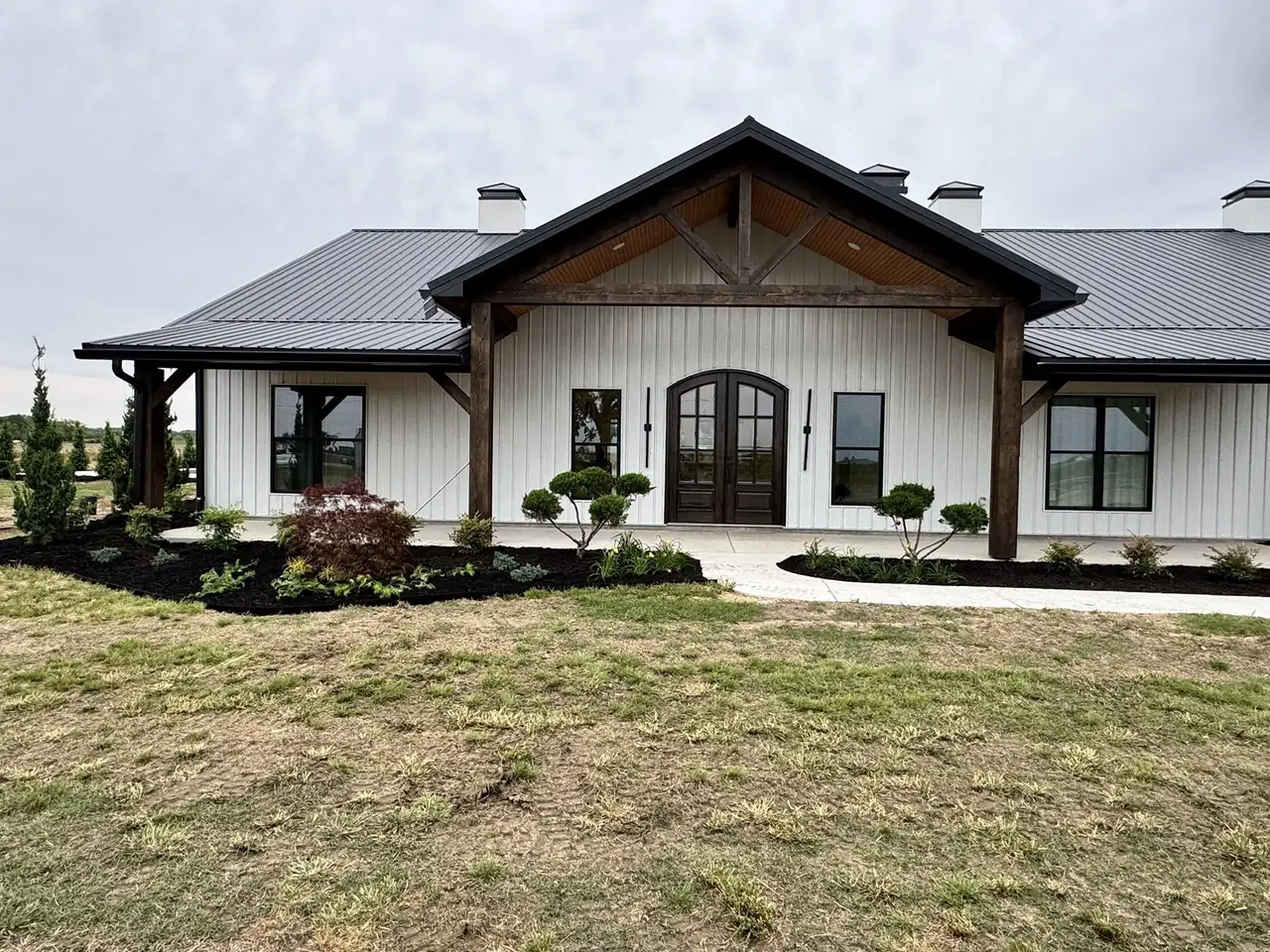 Young shrubs and topiary at a farmhouse entry