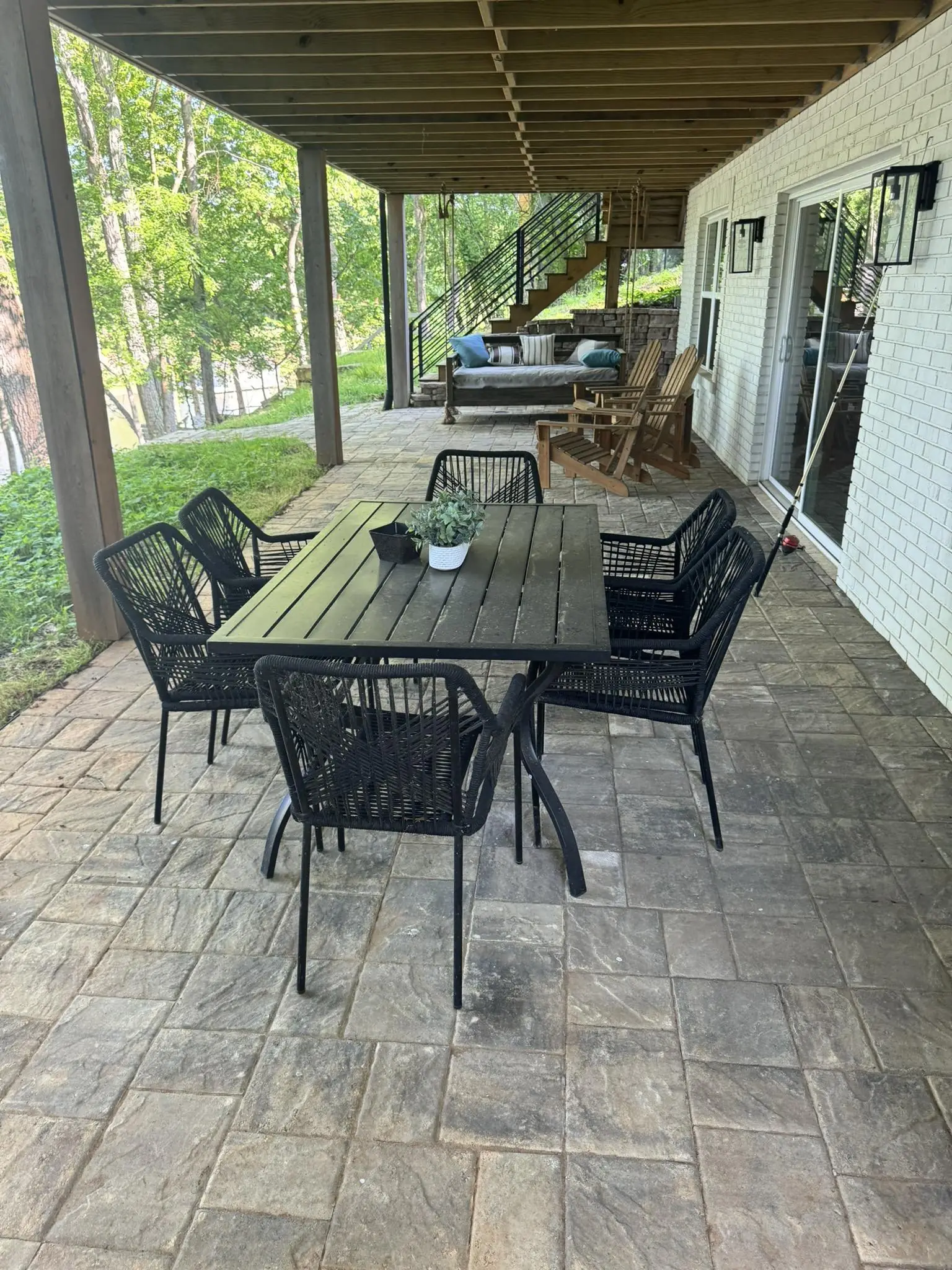 A paver patio with a dining table under a deck