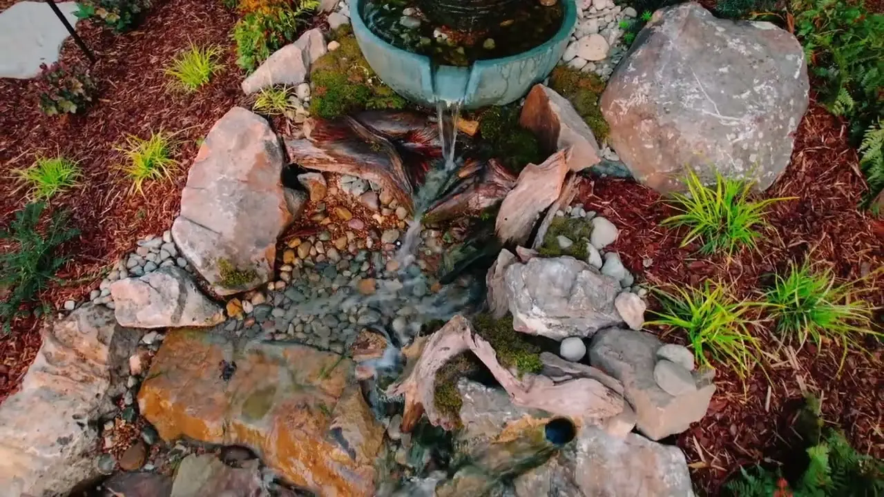 A spilling bowl fountain running into a rocky stream bed, from the Designs of Nature film