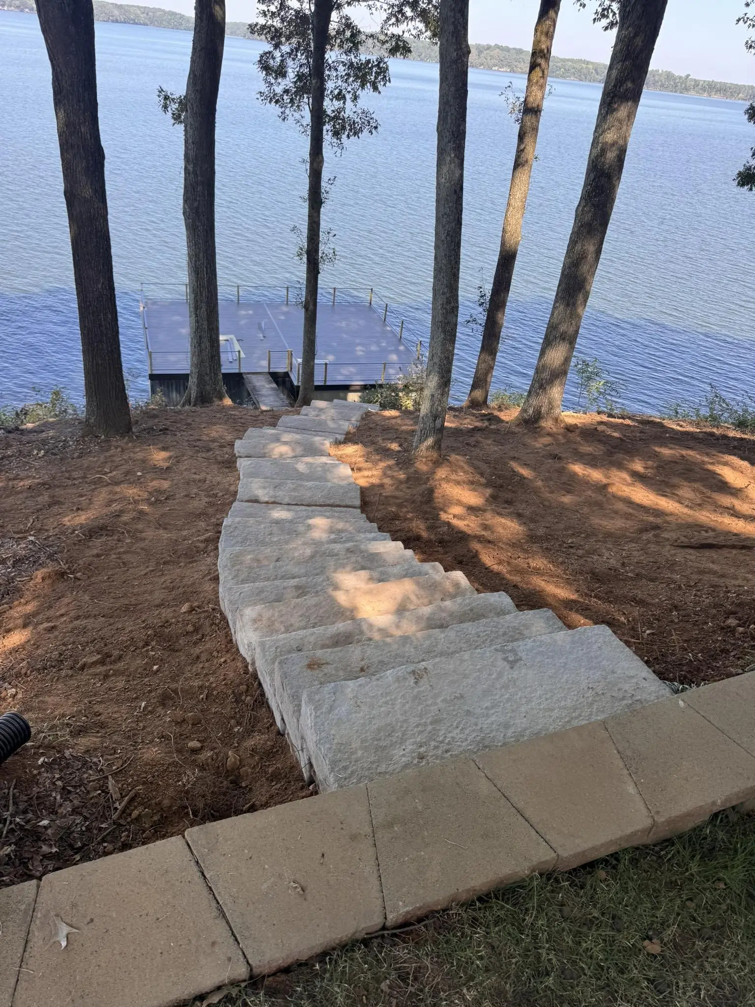 Cut stone steps leading down a slope to the lake