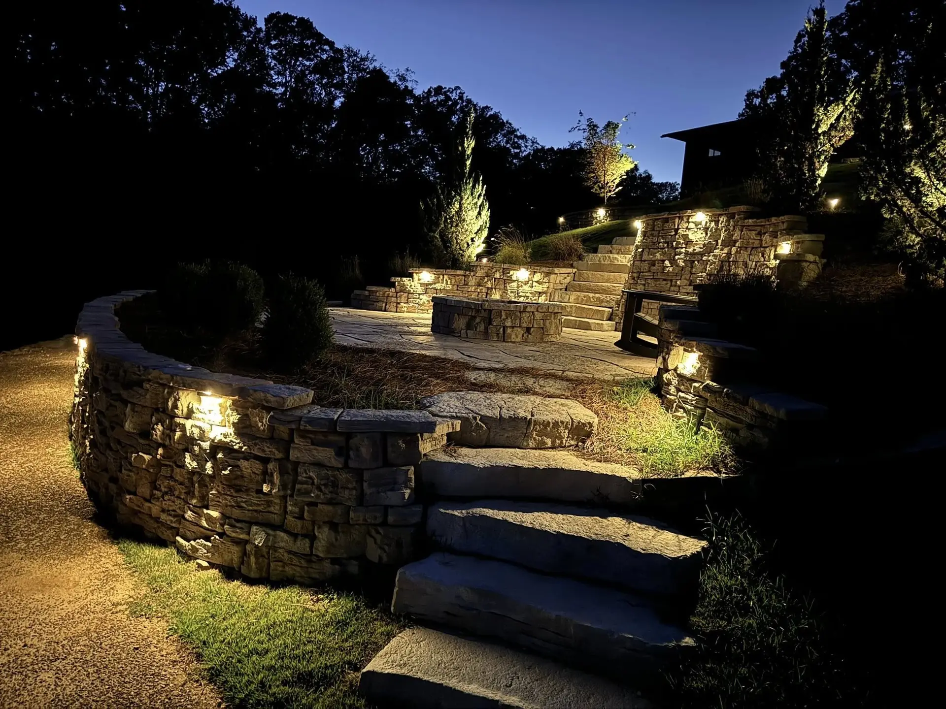 Tiered stone walls and broad stone steps lit at night